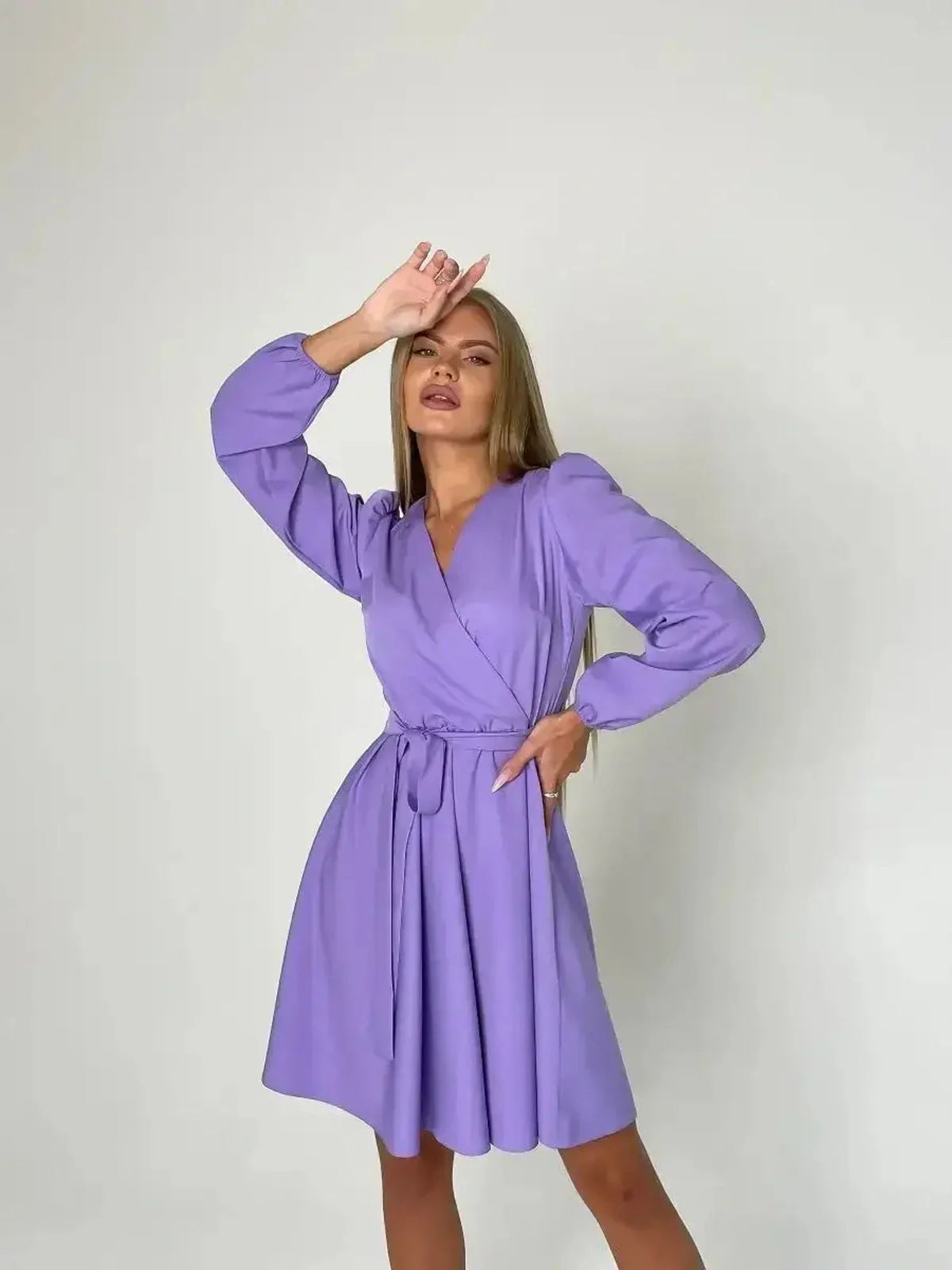 Stylish model wearing the Lilac Charm mini dress in lavender with V-neckline and adjustable tie belt.