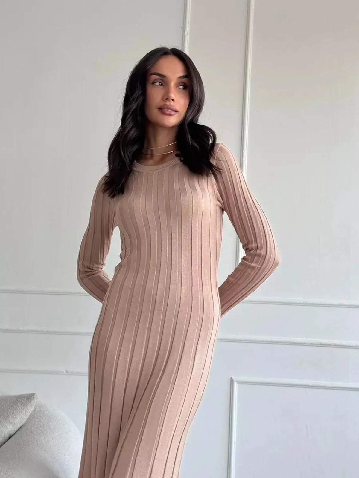 Woman in Sahara Curve Maxi Dress, showcasing soft ribbed texture and elegant silhouette in sandstone beige.