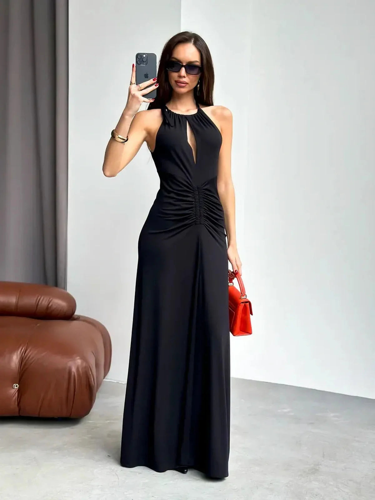 Elegant black maxi dress with halter neckline and front keyhole detail, styled for evening sophistication.