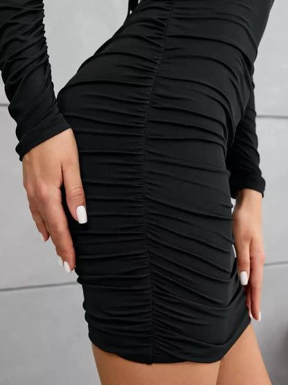 Close-up of ruched black mini dress showcasing its figure-hugging design and elegant silhouette.