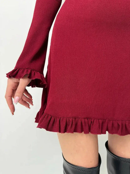 Close-up of a ribbed knit red mini dress featuring romantic ruffles at the cuffs and hem, perfect for a flirty fall look.