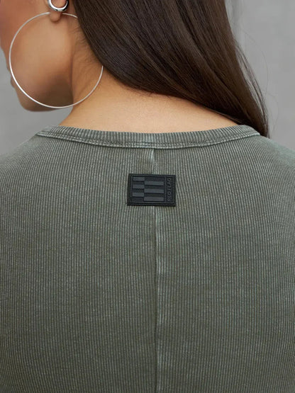 Detail of the Olive Line Maxi Dress showing black label on the back collar against khaki green ribbed fabric.