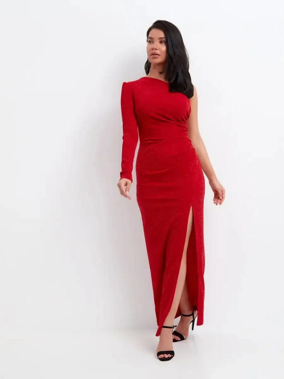Model showcasing the Maxi Dress Radiance Curve, a glittery red one-shoulder dress with a thigh-high slit.