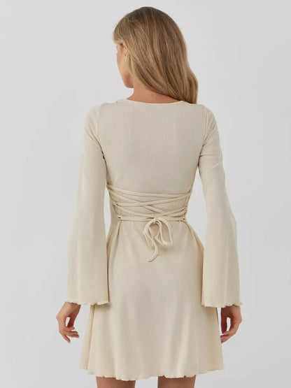Back view of the Sculpted Grace mini dress showcasing its flared sleeves and cinched waist design.