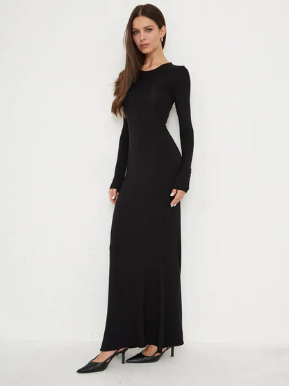 Model wearing Sculpted Noir full-length black dress with long sleeves and a mermaid hem.