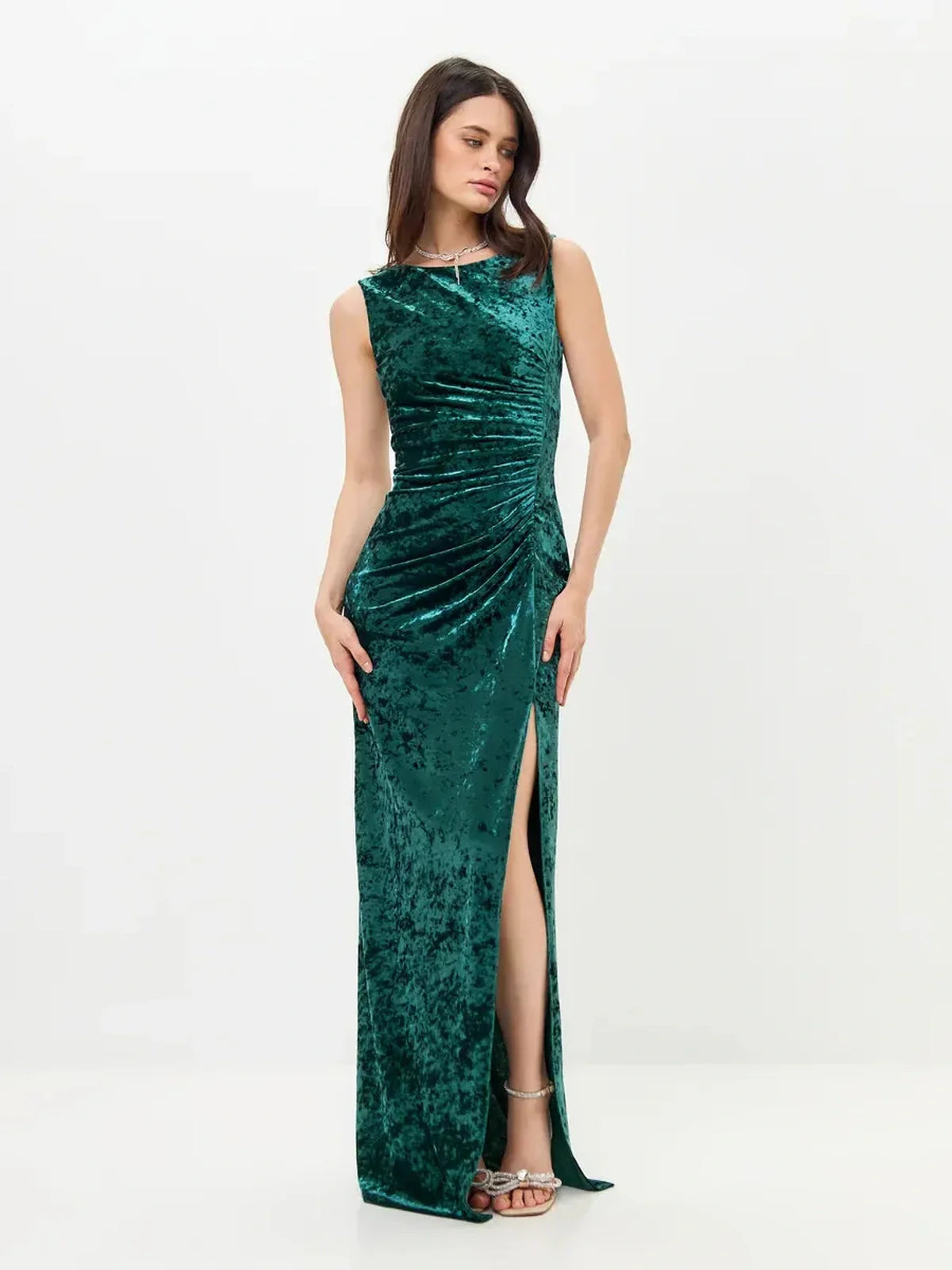 Elegant green velvet Aura Maxi Dress with sleek fit, back slit, and ruching, ideal for formal events.