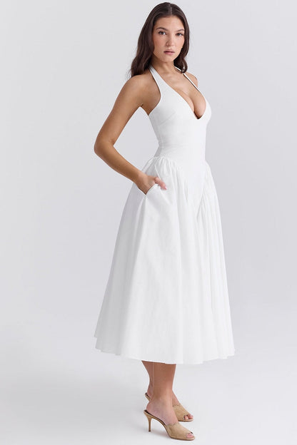 Elegant white maxi dress with a halter neck and pockets, perfect for weddings and summer events.