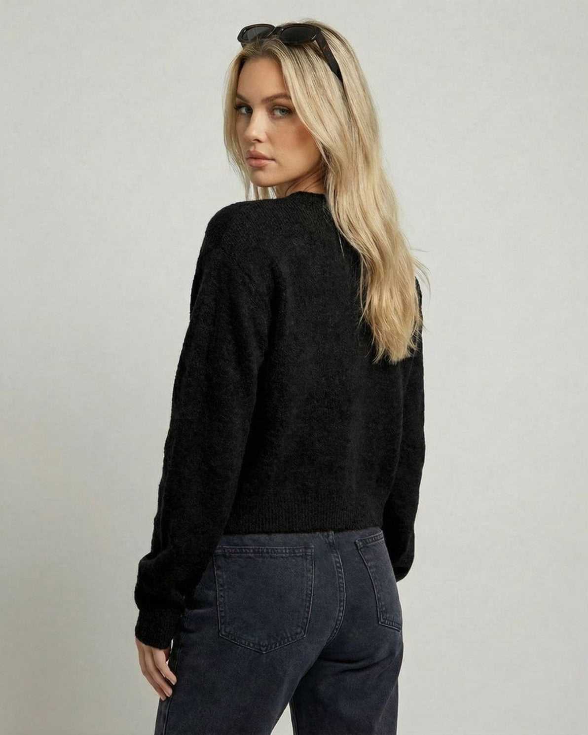Back view of a woman wearing the Noir Cardigan by Lauven, featuring a relaxed fit and long sleeves.