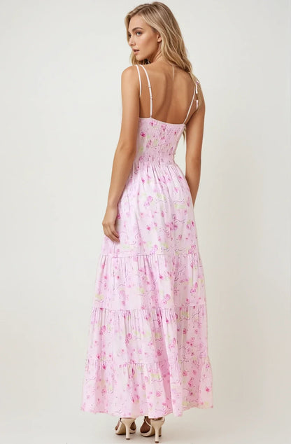 Back view of the Amélie Dress, a pastel floral maxi dress with spaghetti straps and a tiered skirt.