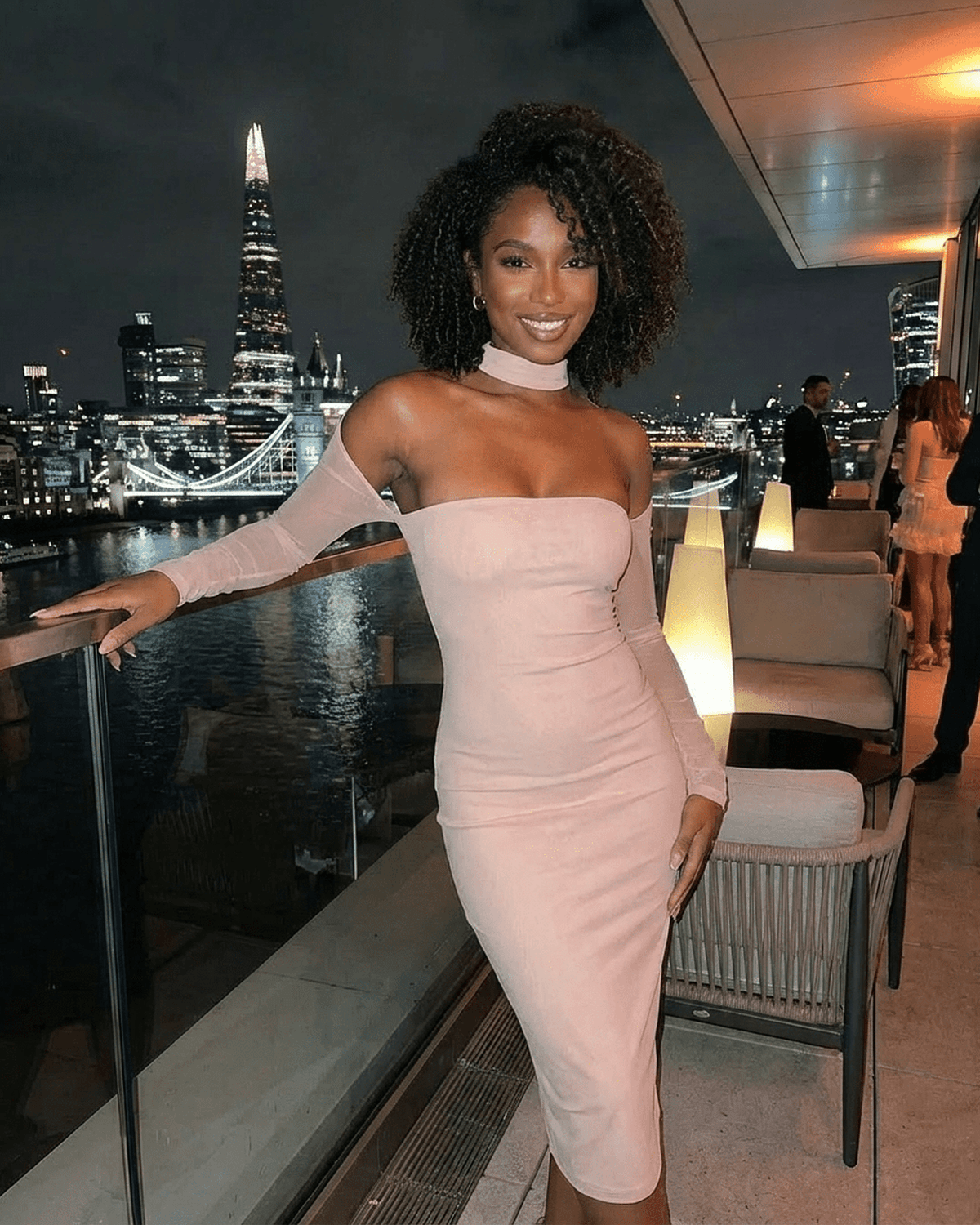 Model wearing Arden Blush Dress by Lauven, showcasing bodycon fit and elegant style against a city backdrop.