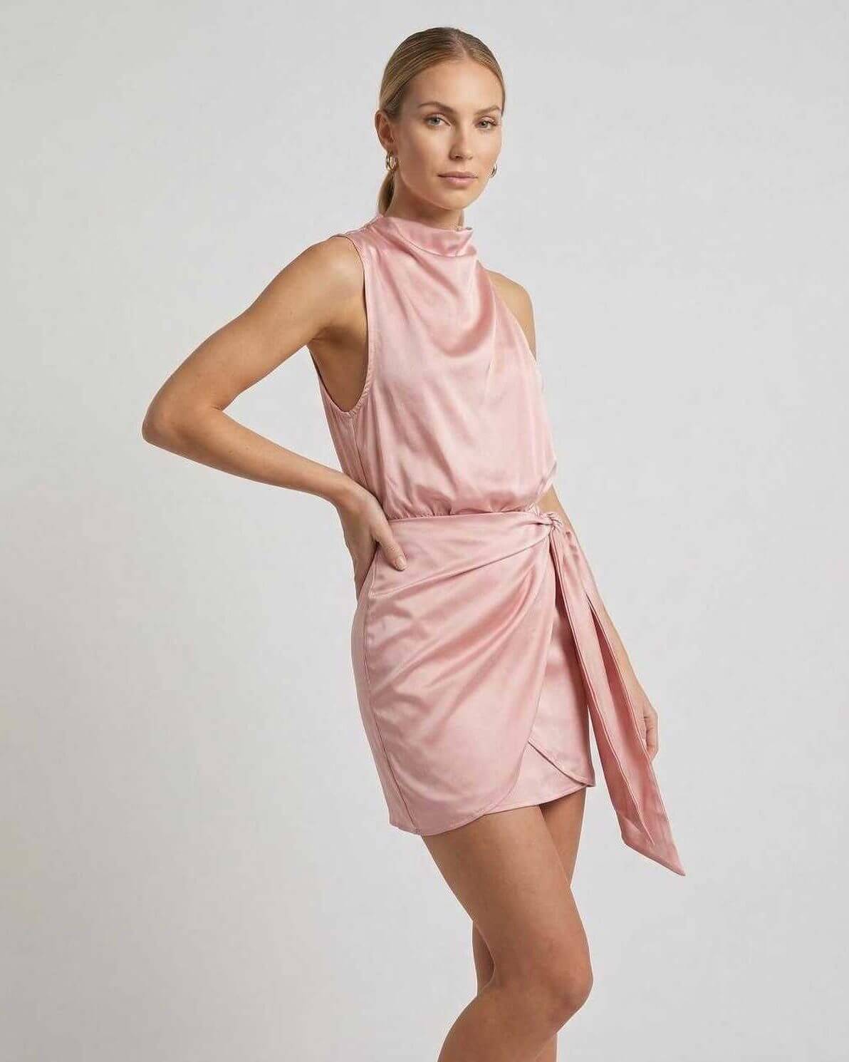 Aria Mini Dress from Lauven: Pink satin mini dress with draped high neck and wrap tie detail, sleeveless design.