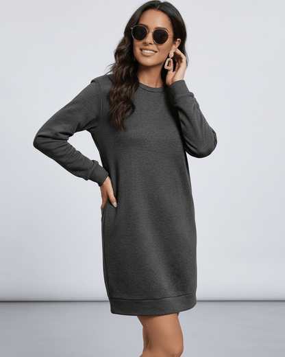 Model wearing Lauven Astrid Mini Dress in dark charcoal with sunglasses, showcasing a relaxed fit and pockets.