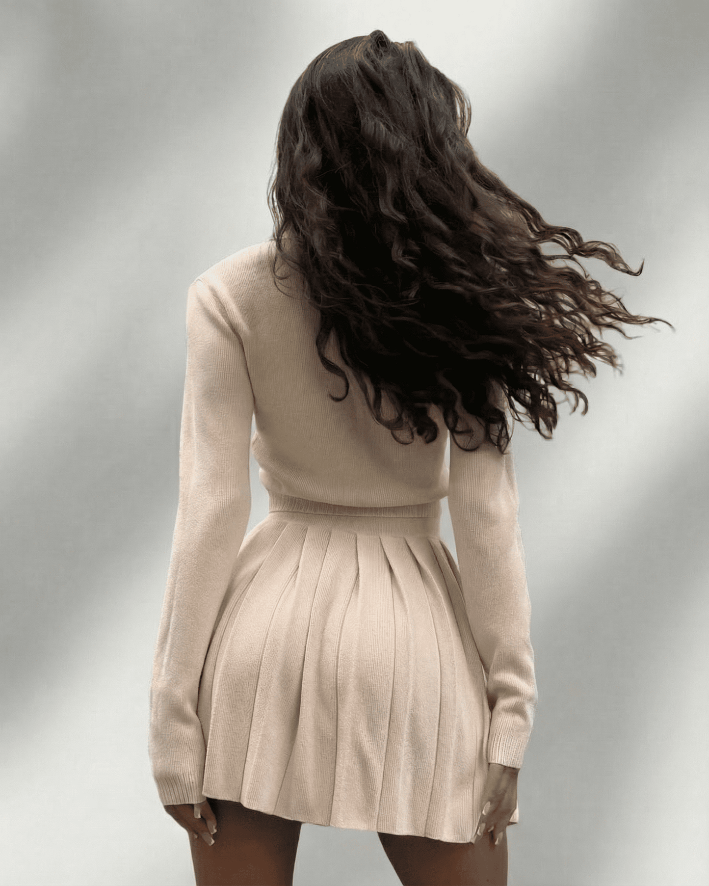 Aurelia Two-Piece Set by Lauven featuring a women’s knit cardigan and pleated mini skirt in soft beige.