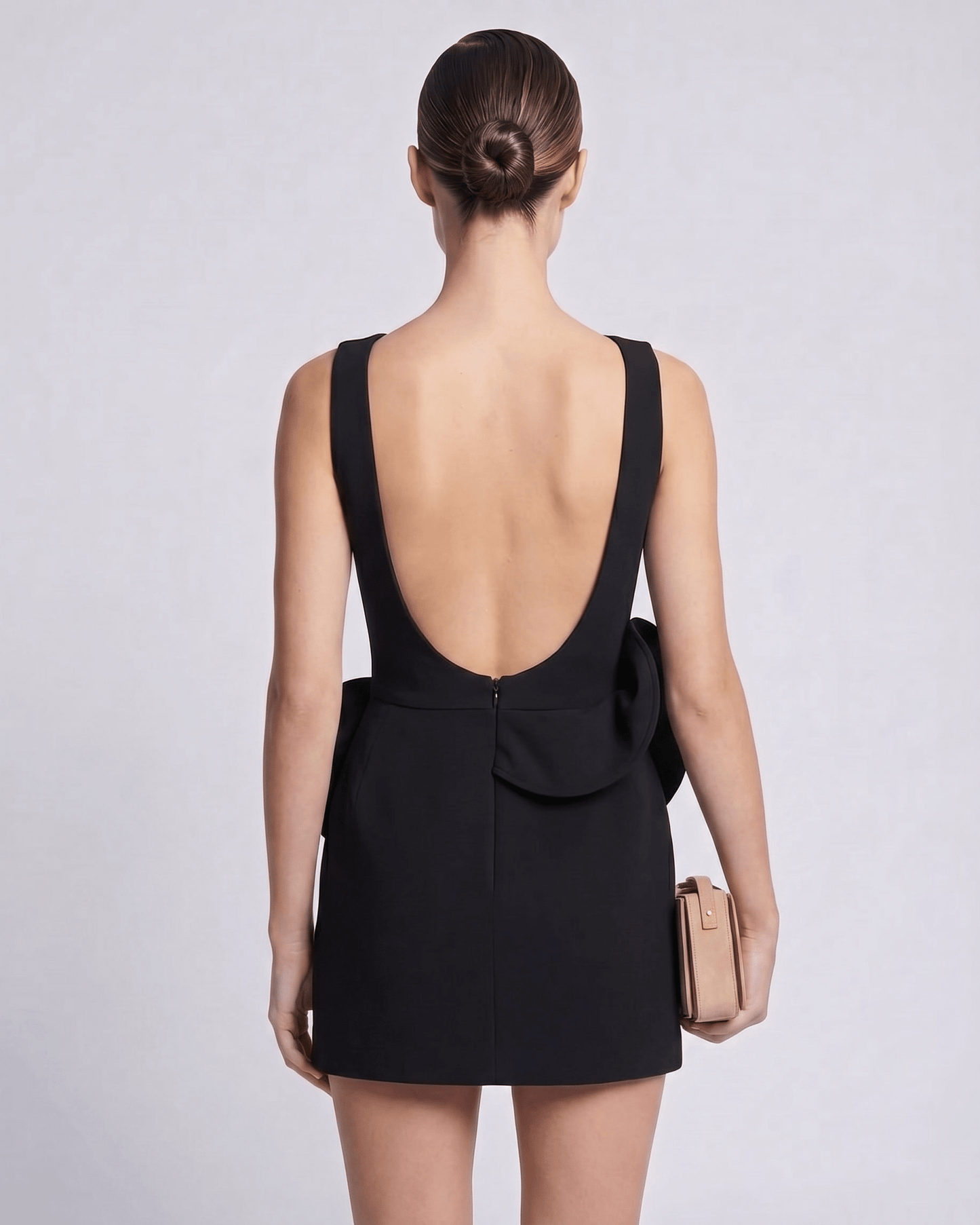 Aurelle Mini Dress in black, featuring a deep back neckline and sculptural waist detail, by Lauven.