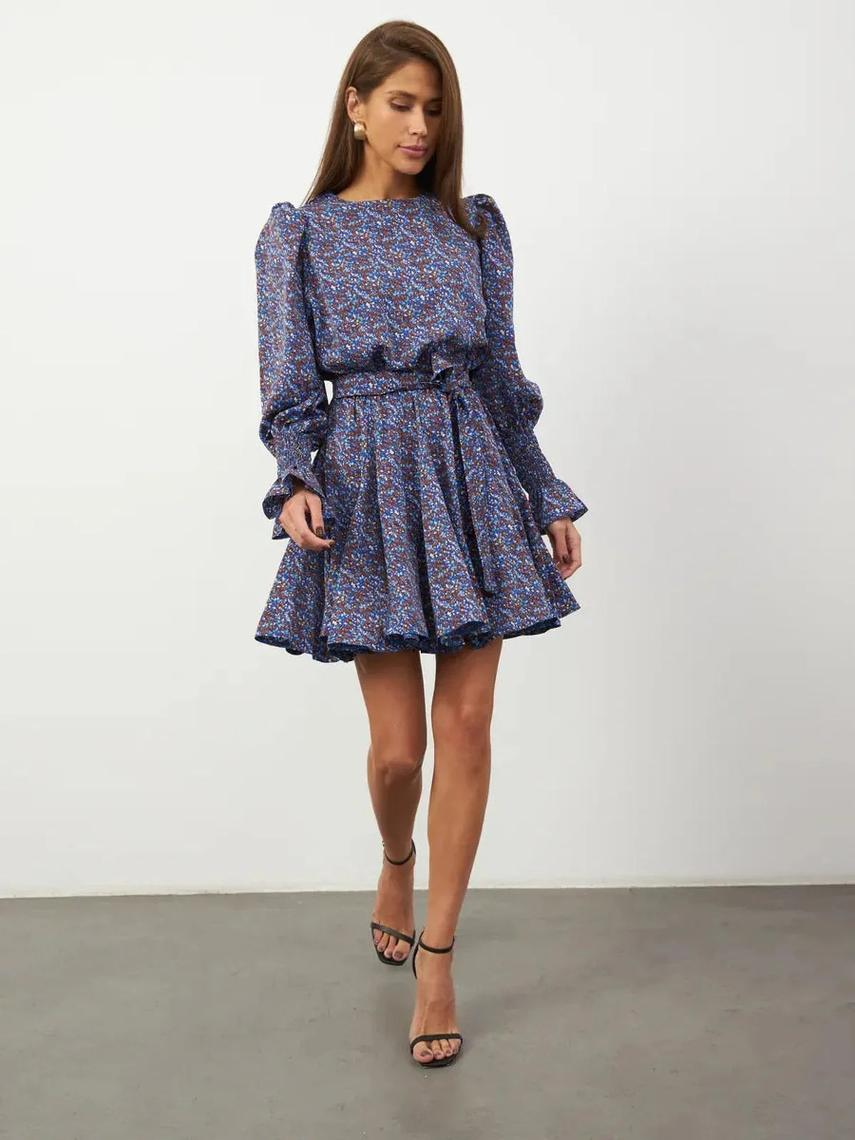 Model wearing the Azure Bloom Mini Dress, featuring vibrant blue florals, ruffled sleeves, and a flared skirt.