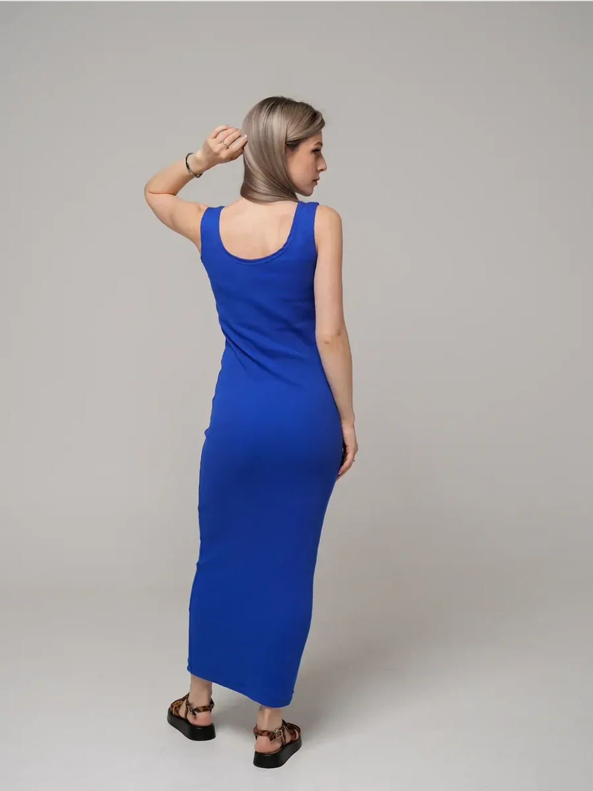Model wearing the Azure Elegance Maxi Dress in cobalt blue, showcasing its sleek ribbed silhouette from the back.