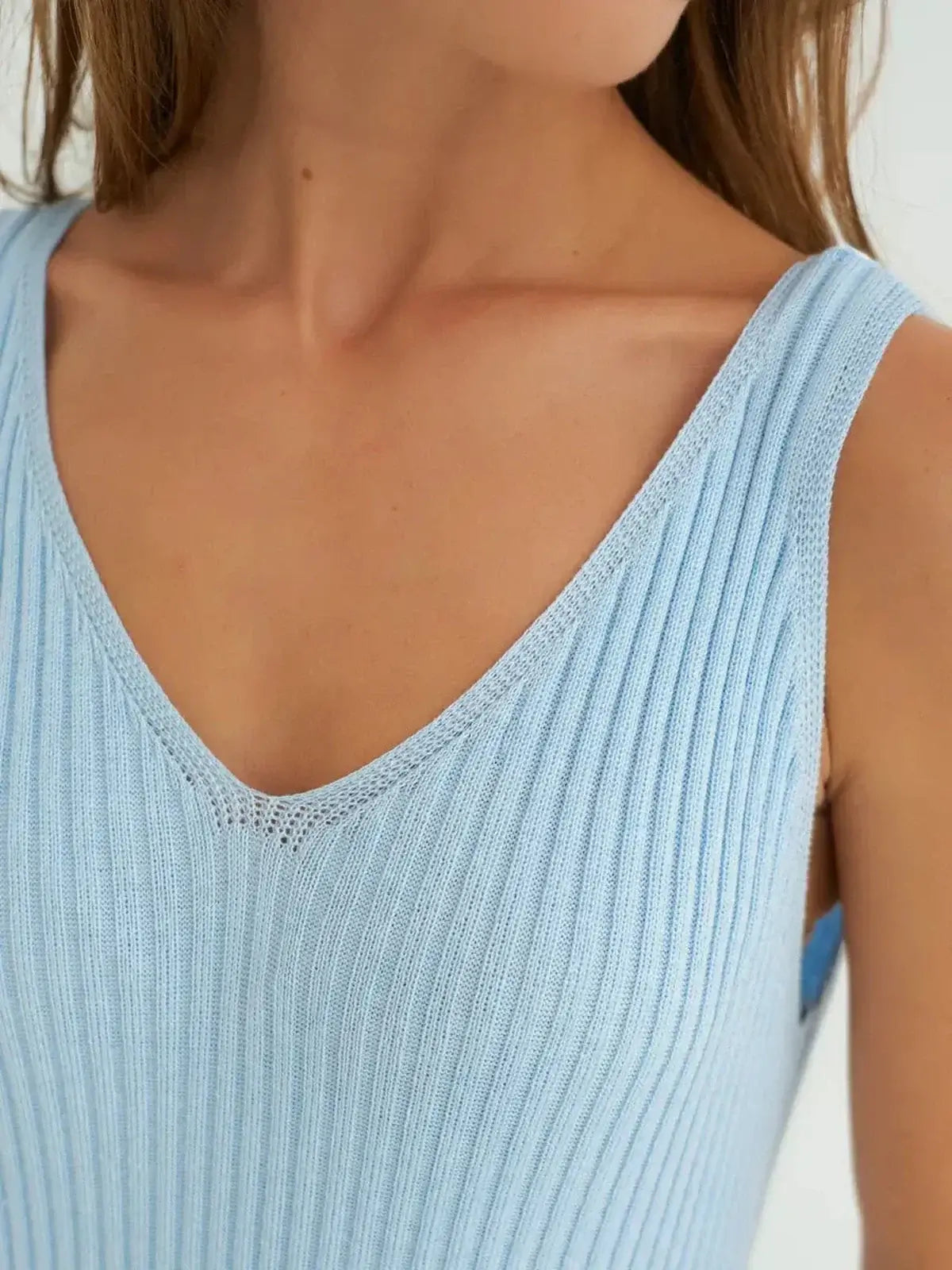 Close-up of a sleeveless, ribbed knit dress in sky blue, featuring a flattering V-neckline for effortless elegance.