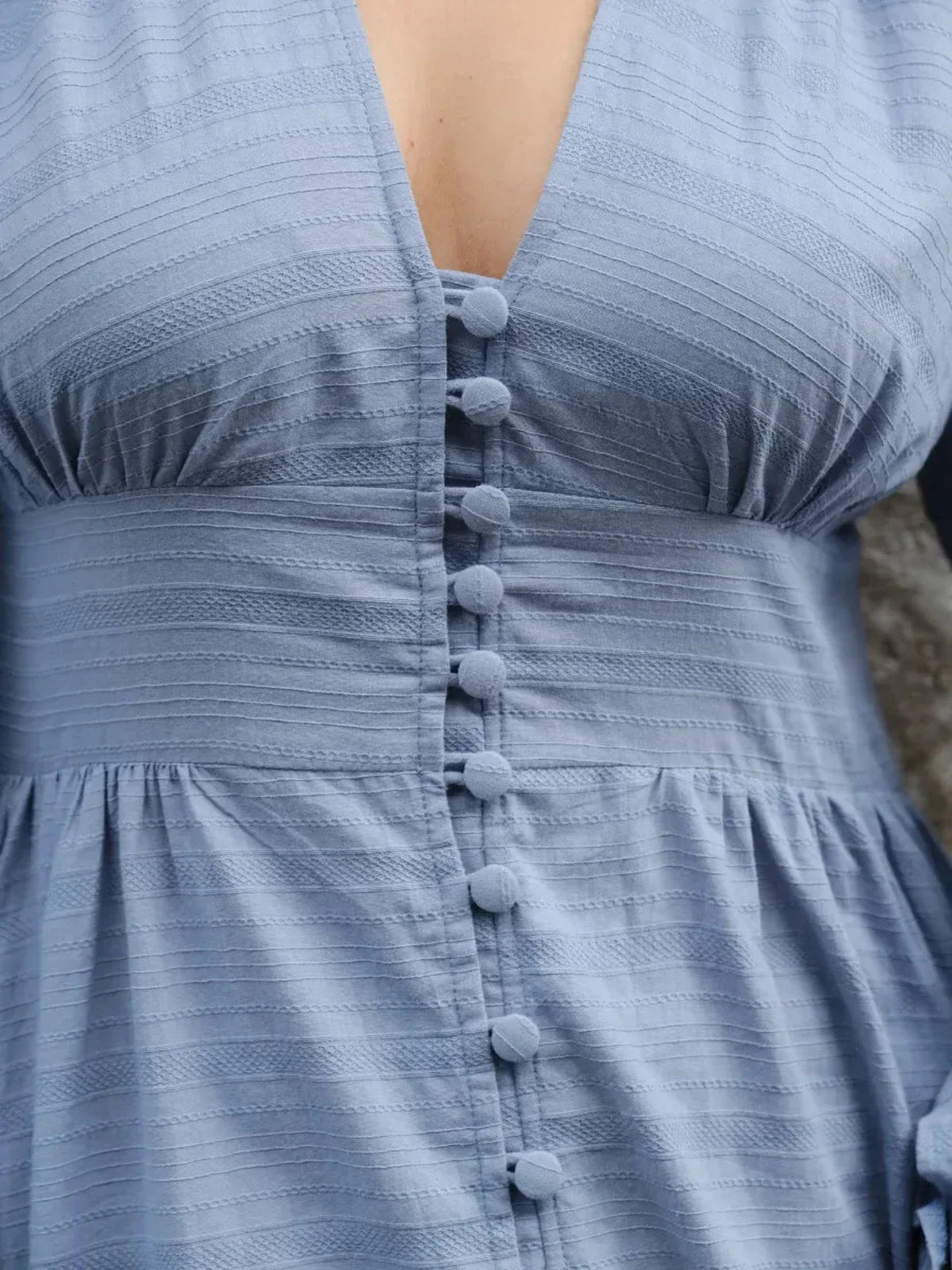 Close-up of Azure Grace Maxi Dress showcasing textured blue cotton fabric and decorative button details.