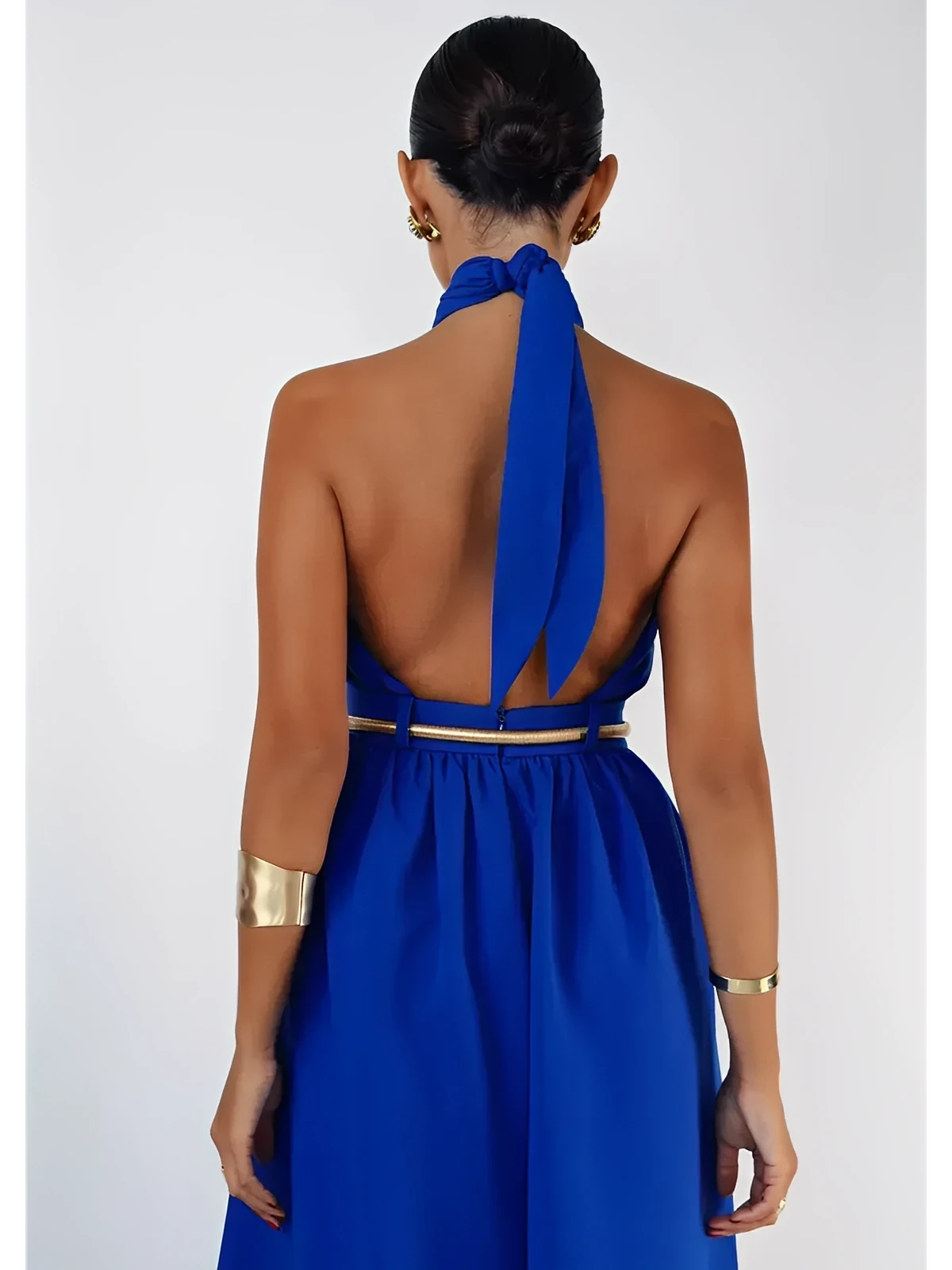 Back view of a model in an Azure Halter Jumpsuit, showcasing its open back and wide-leg silhouette.
