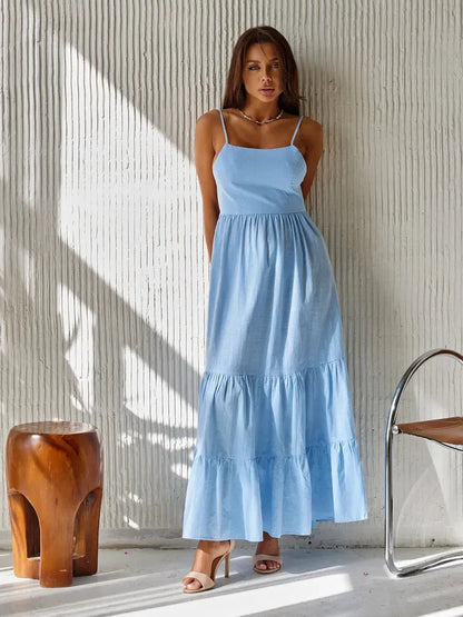 Model wearing Azure Muse Maxi Dress in sky-blue, showcasing its backless design and tiered cotton elegance.