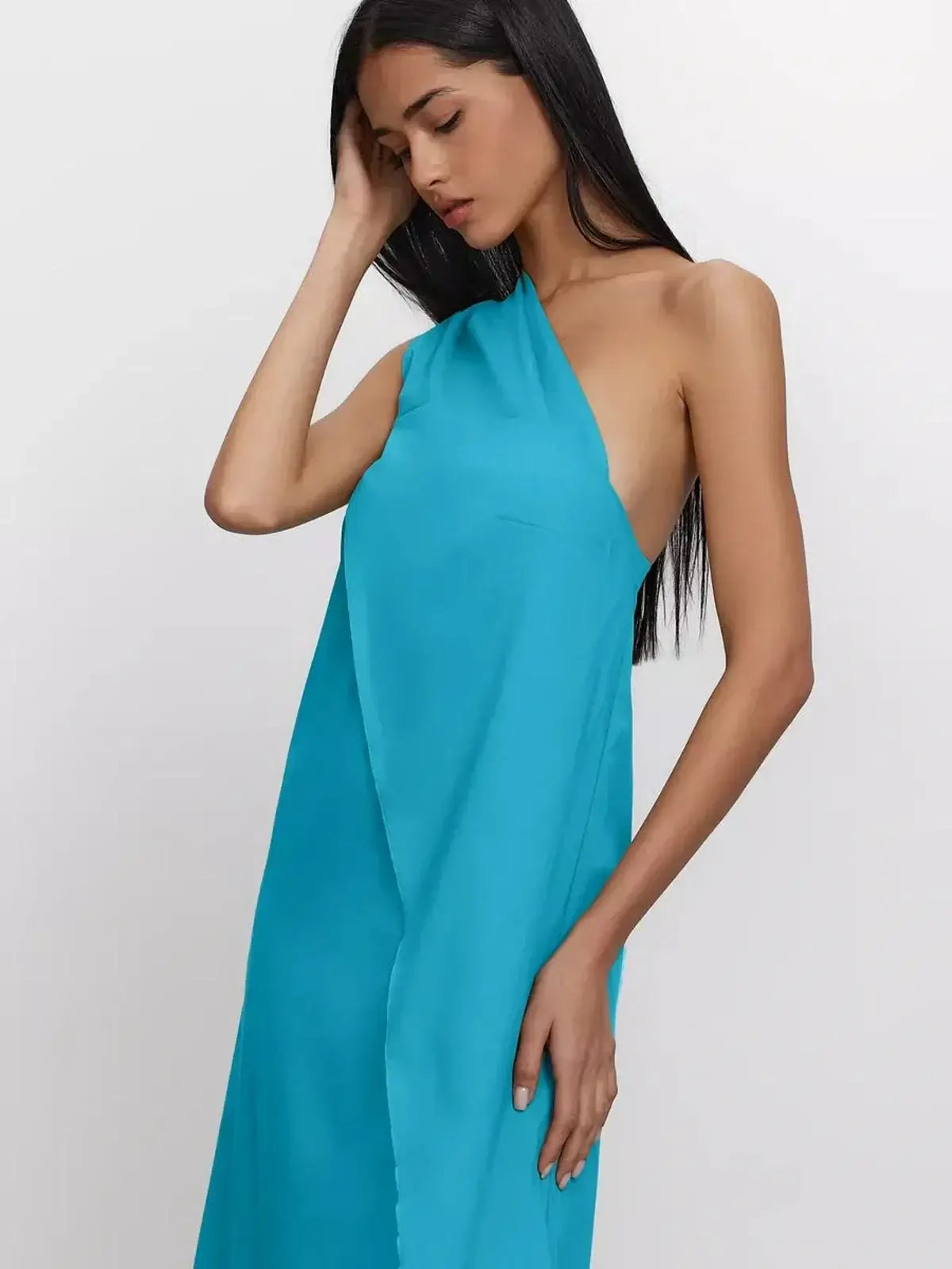 Model wearing the Azure Sway Maxi Dress in vibrant turquoise, showcasing a one-shoulder design and flowy silhouette.