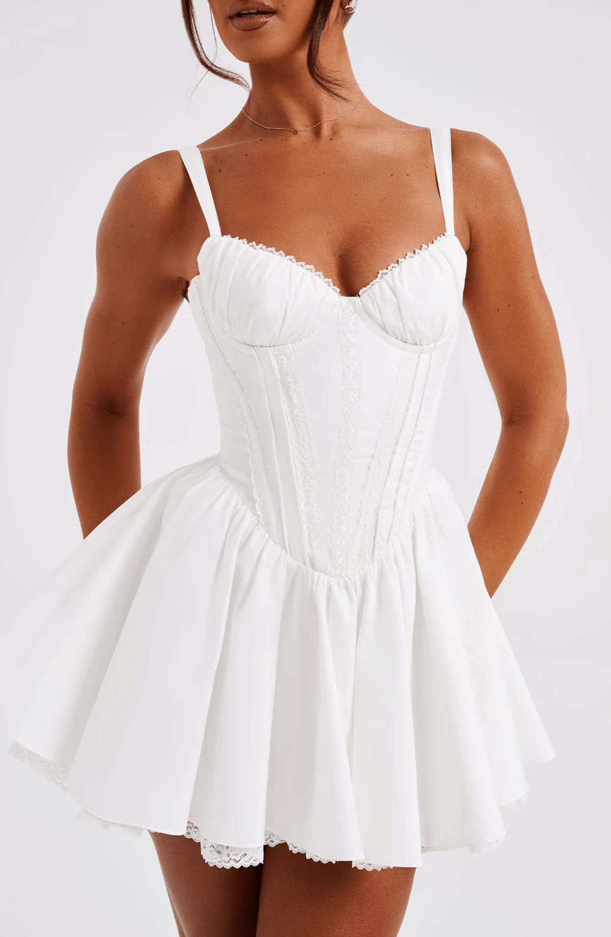 Elegant white mini dress with corset design and flared skirt, perfect for summer gatherings and formal occasions.