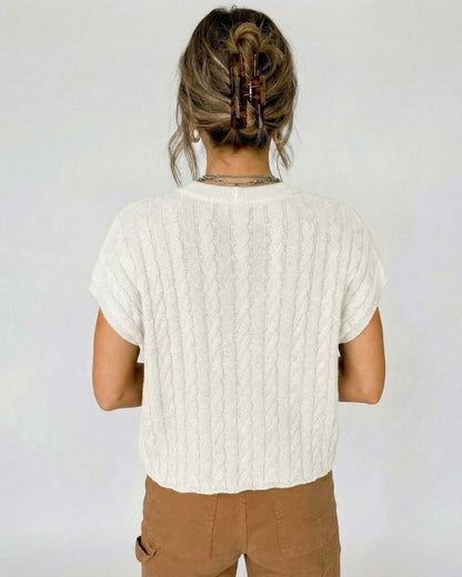 Back view of a woman wearing the Bianco Sweater by Lauven, showcasing its elegant cable knit design.