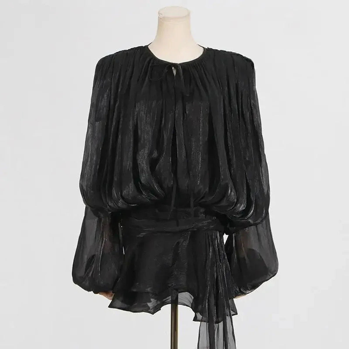 Elegant black chiffon blouse with billowy sleeves and a tie neck detail, perfect for formal or casual occasions.