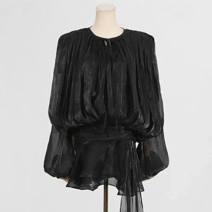 Elegant black chiffon blouse with billowy sleeves and a tie neck detail, perfect for formal or casual occasions.