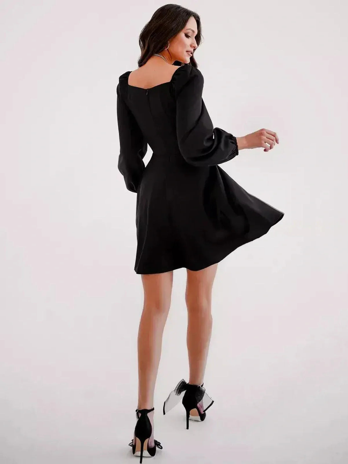 Back view of a chic black mini dress with puff sleeves and a square neckline, perfect for cocktail or summer events.