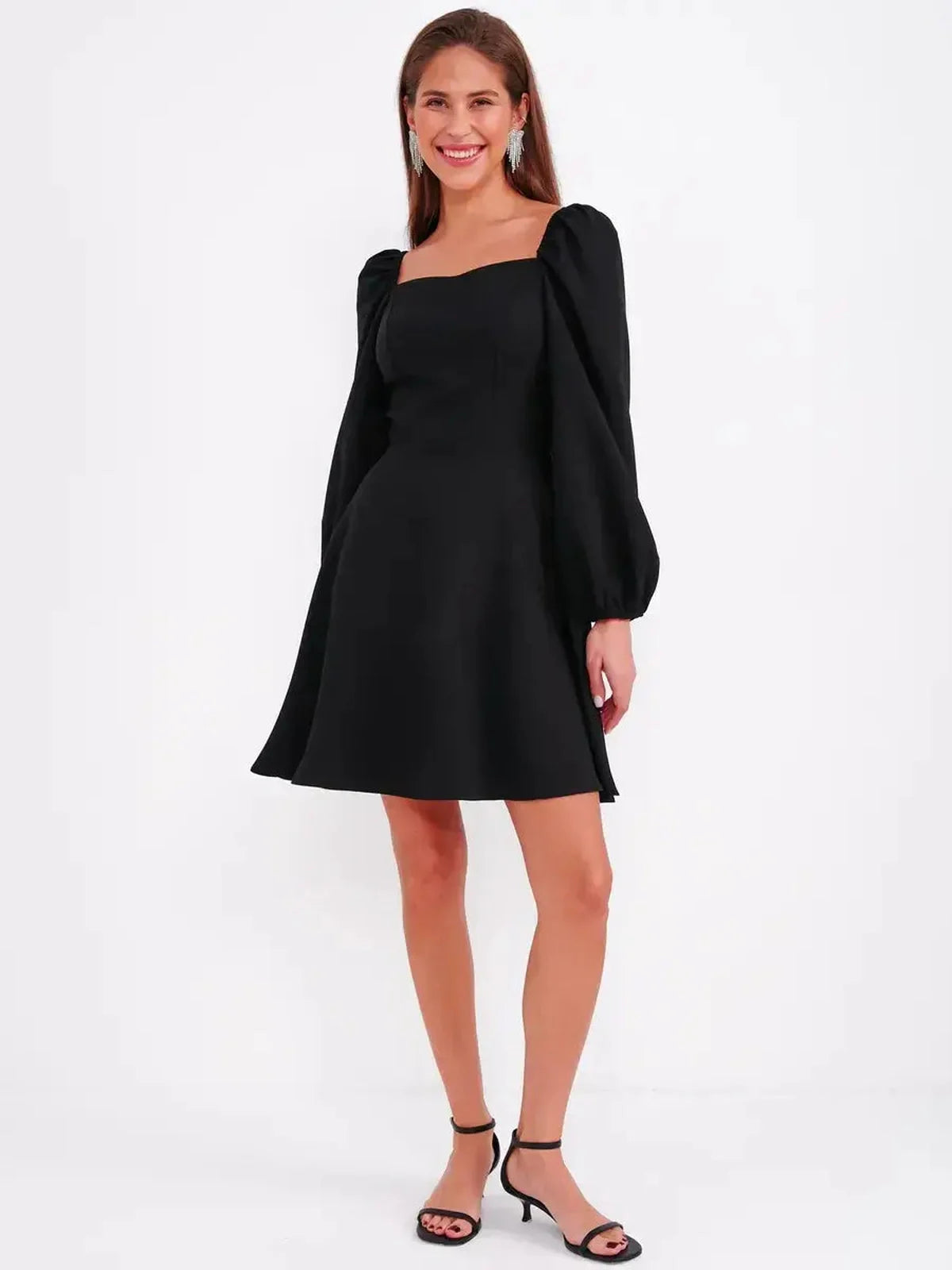 Black mini dress with sculpted bodice and puff sleeves, perfect for wedding guest or cocktail events.