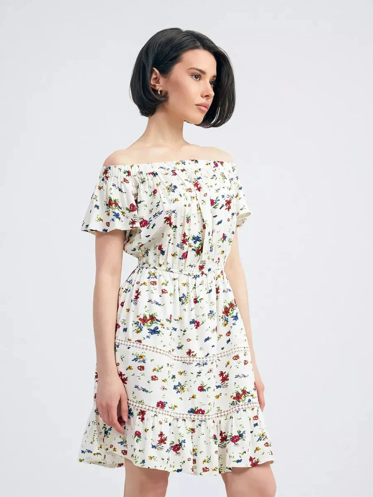 Model wearing the Bloom Off-Shoulder romantic summer dress with multicolor floral print.