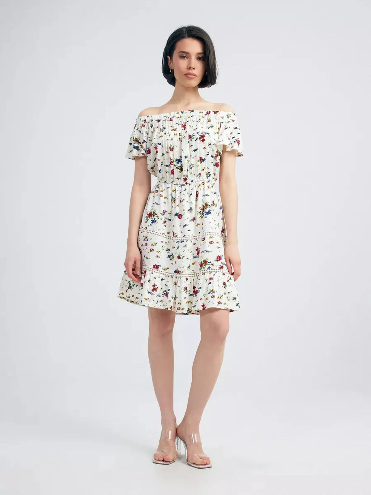 Model wearing the Bloom Off-Shoulder dress with multicolor floral print and embroidered trims, ideal for summer elegance.