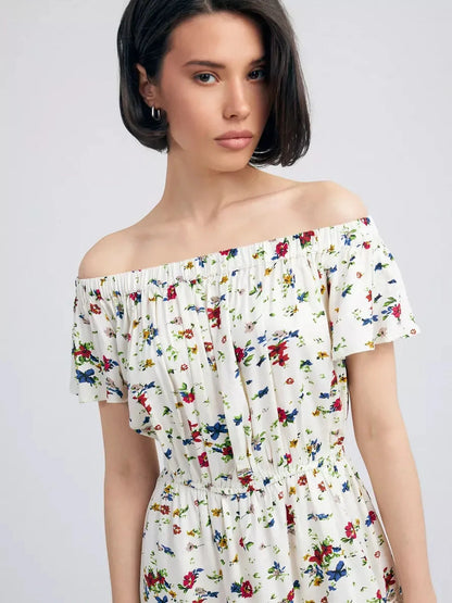 Model wearing Bloom Off-Shoulder dress featuring floral print and off-the-shoulder neckline for summer elegance.