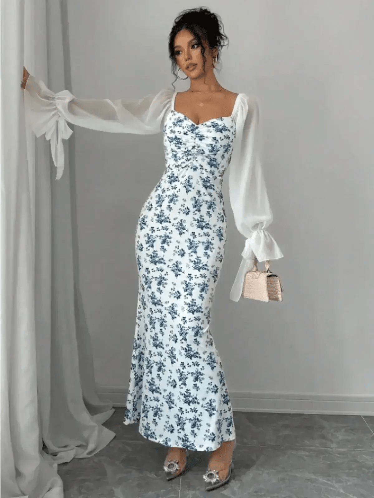 Model showcasing the Bluebelle Maxi Dress with floral design and sheer sleeves, embodying elegance and femininity.