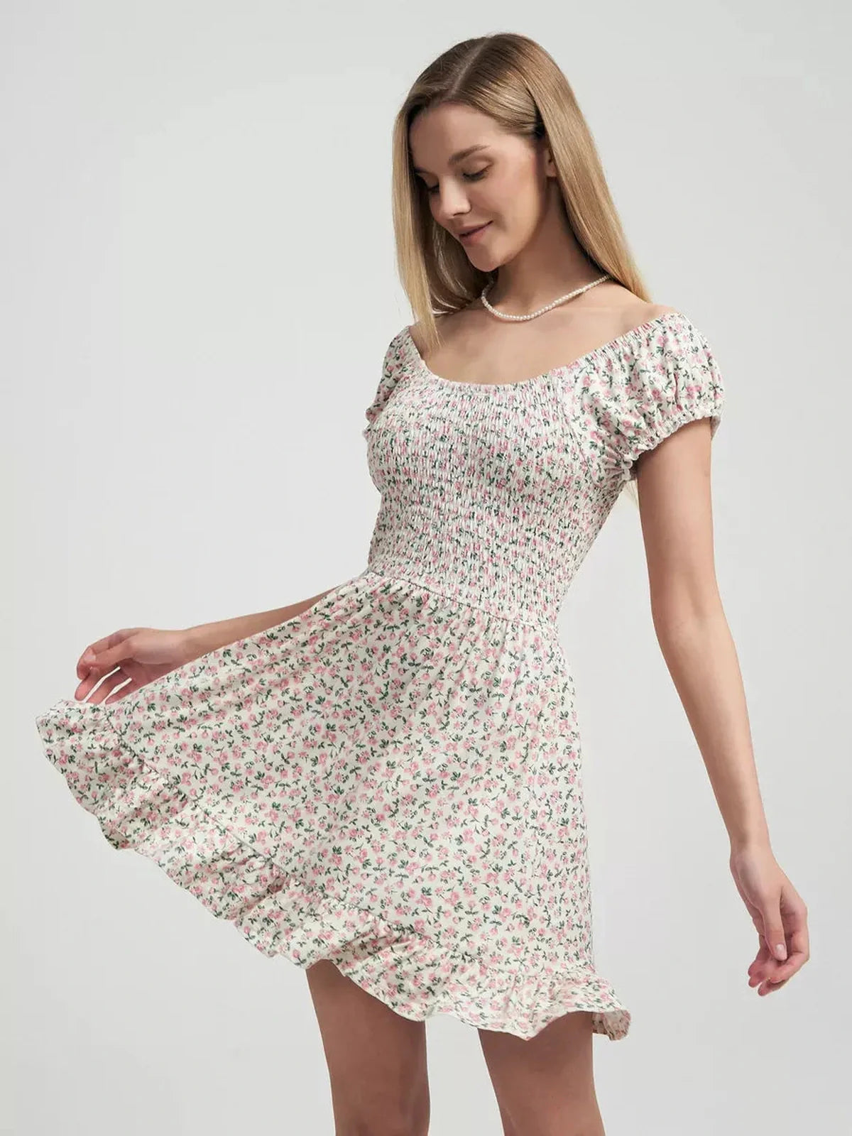 Stylish woman twirling in a Blush Blossom floral summer dress with pink prints and ruffled hem, perfect for summer outings.