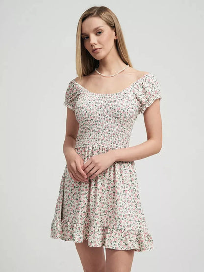 Model wearing the Blush Blossom summer dress with pink floral prints and a ruffled hem, ideal for romantic occasions.