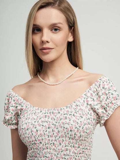 Close-up of a model wearing the Blush Blossom dress with floral prints and a smocked bodice for a feminine summer look.