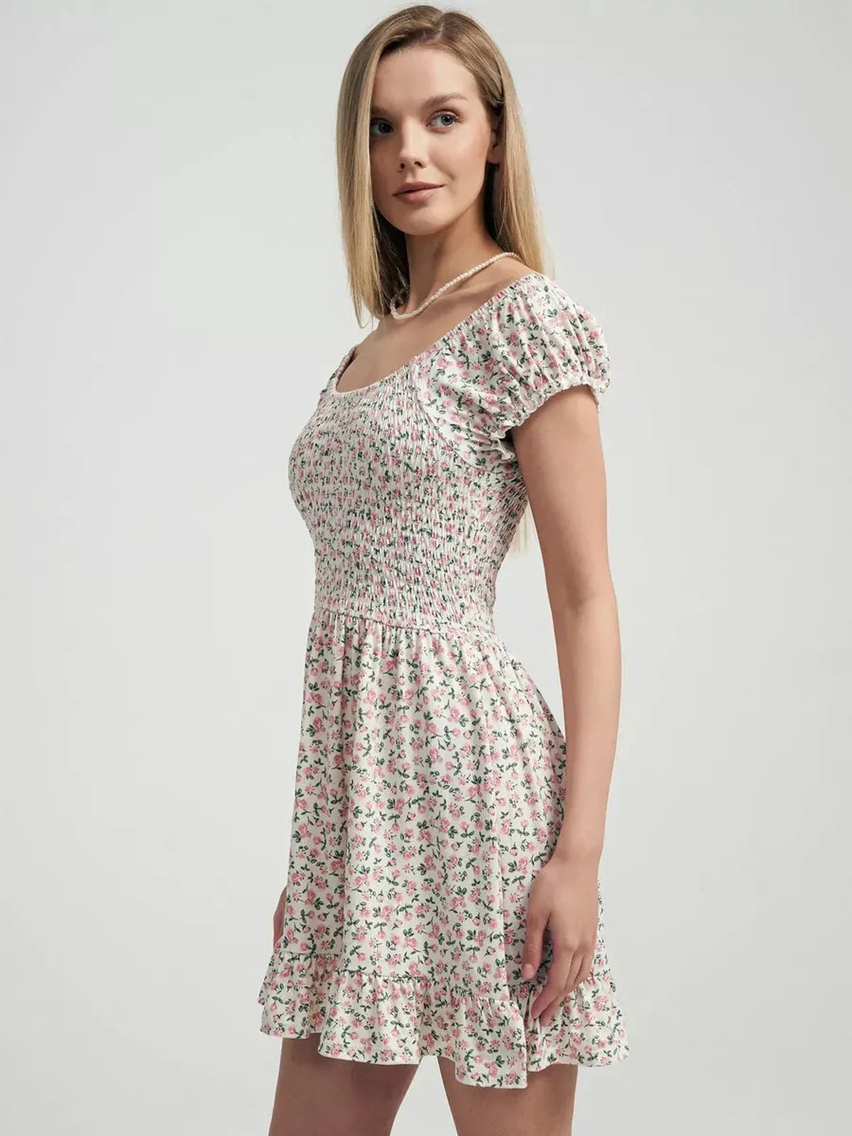 Blush Blossom summer dress with pink floral prints, smocked bodice and ruffled hem, perfect for garden parties.