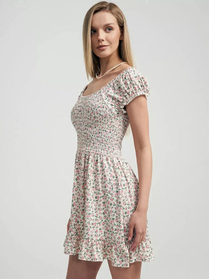 Blush Blossom summer dress with pink floral prints, smocked bodice and ruffled hem, perfect for garden parties.