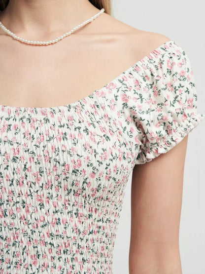 Close-up of the Blush Blossom dress showing smocked bodice and floral patterns in soft pink and white.