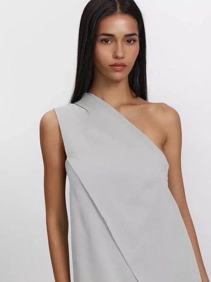 Model wearing a one-shoulder Cascade Maxi Dress in breathable cotton, showcasing a minimal and elegant design.