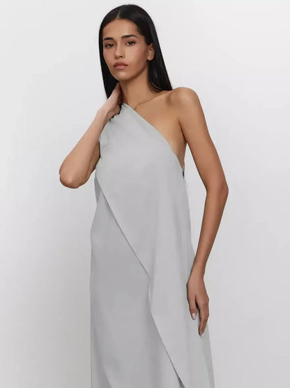Model wearing a light gray one-shoulder Cascade Maxi Dress made from breathable cotton, showcasing elegant A-line silhouette.