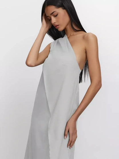 Model wearing Cascade Maxi Dress, one-shoulder silhouette in soft grey cotton, showcasing elegant A-line fit.