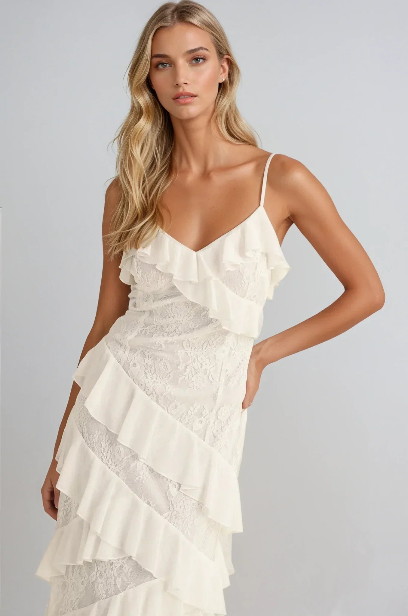 Elegant off-white maxi dress with cascading ruffles and lace inserts, ideal for weddings and formal occasions.