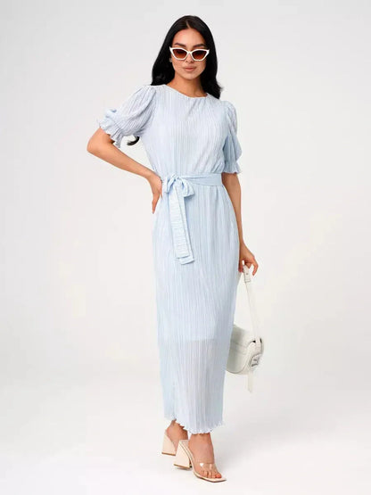 Celeste Flow Maxi Dress in light blue with pleats and waist tie, perfect for summer weddings or formal events.