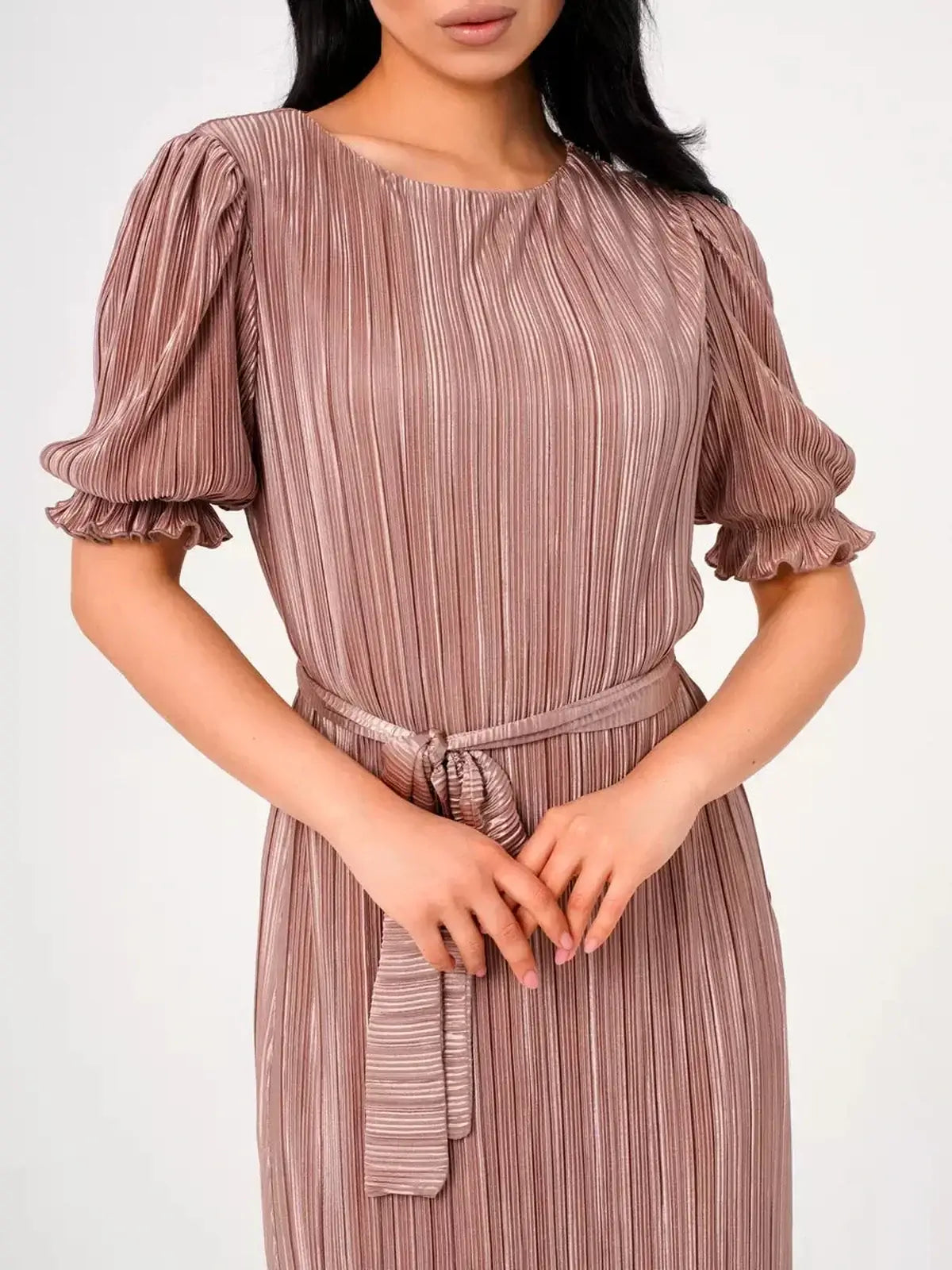 Close-up of a woman wearing the Celeste Maxi Dress in light cappuccino with elegant pleats and puff sleeves.