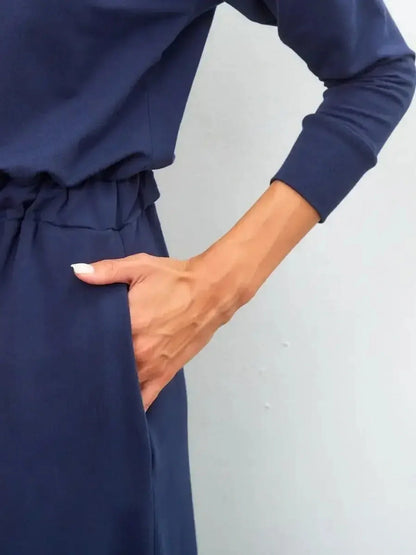 Close-up of woman’s hand in pocket of elegant navy Celeste Maxi Dress, showcasing its modern fit and relaxed style.