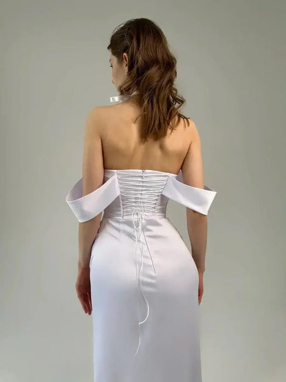 Back view of Celeste Maxi Dress showcasing the corset-inspired lace-up detail and sculptural off-shoulder sleeves.