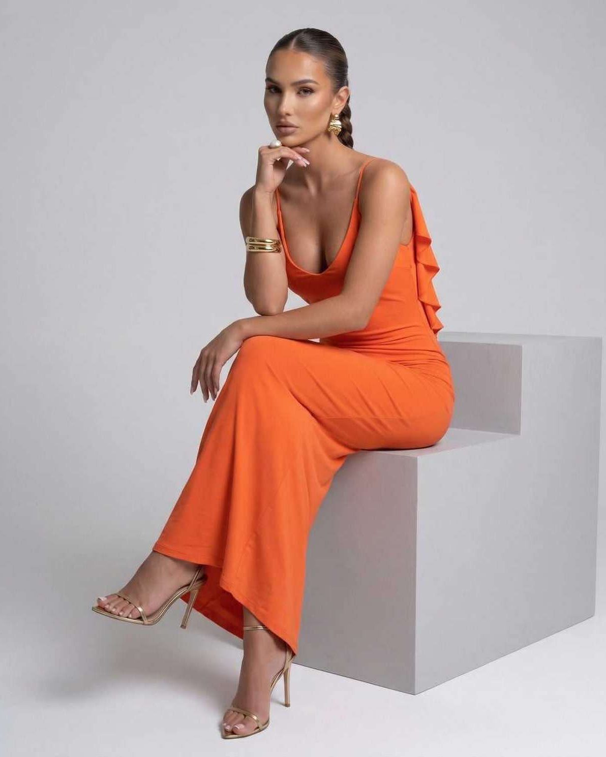 Model wearing the Celeste Maxi Dress in bright orange, showcasing its elegant spaghetti strap design, by Lauven.